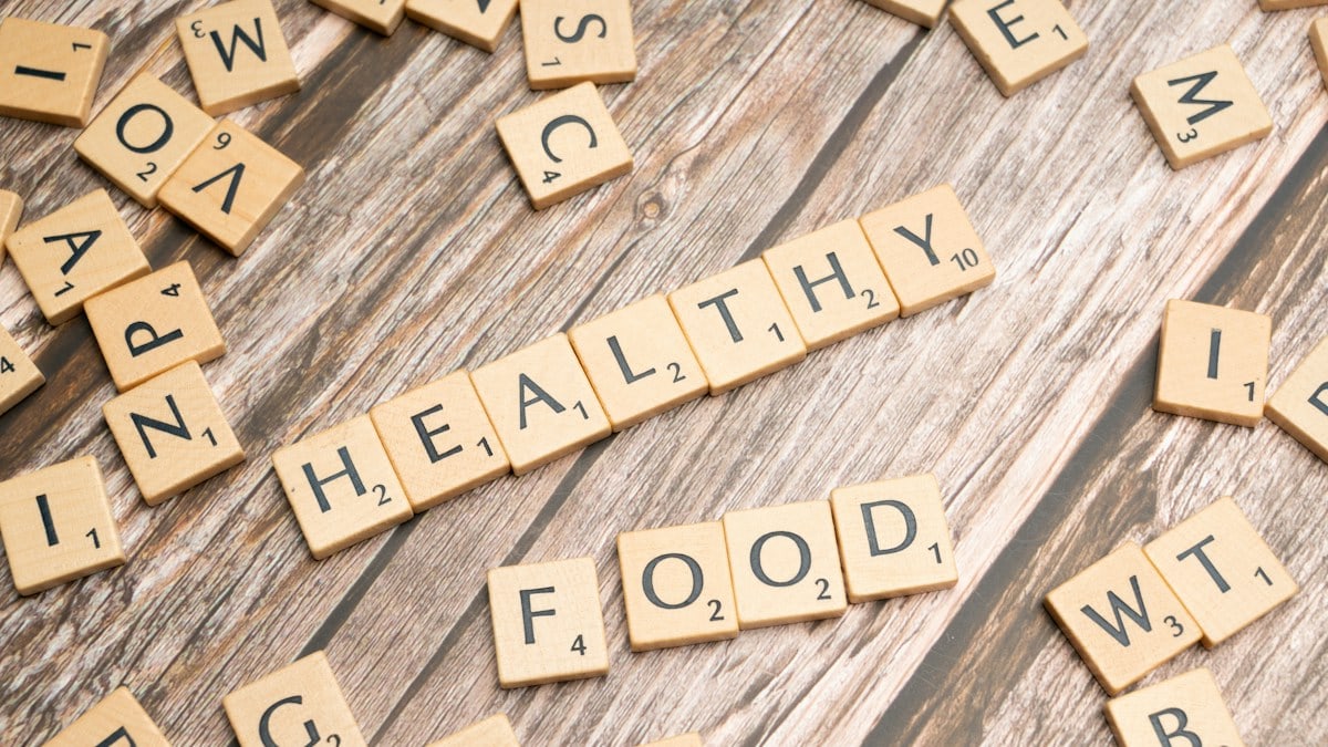 scrabble tiles spelling out the word healthy on a wooden surface